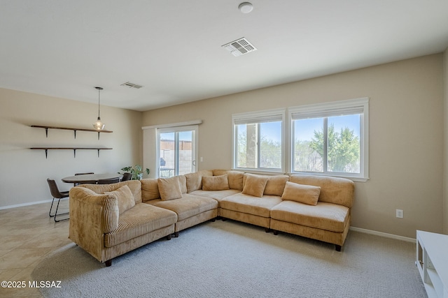 living area with baseboards and visible vents