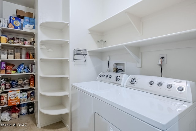 washroom with independent washer and dryer, light tile patterned flooring, and laundry area