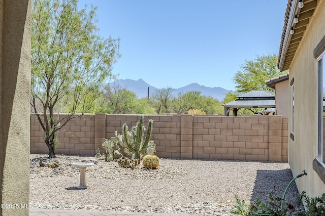 view of yard with a gazebo, fence, and a mountain view
