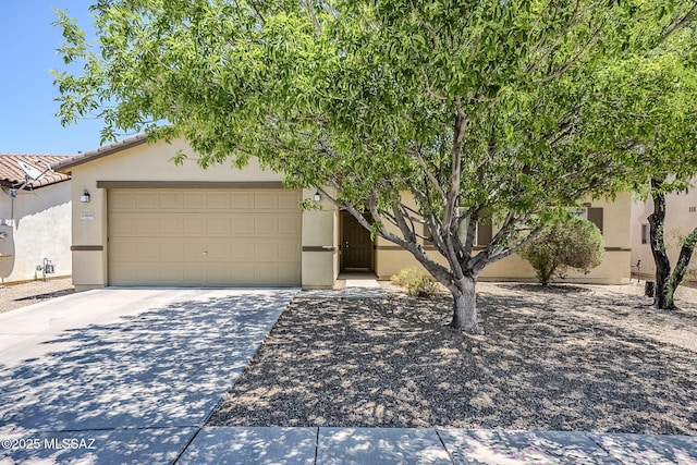 view of front of property with stucco siding, an attached garage, and driveway