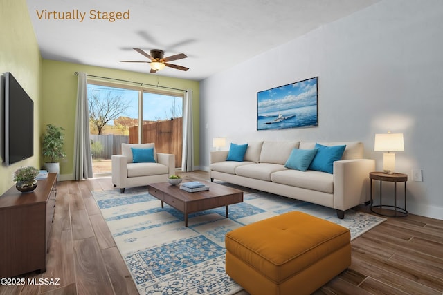 living area featuring wood finished floors, baseboards, and a ceiling fan