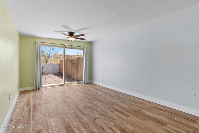 unfurnished room featuring wood finished floors, ceiling fan, and baseboards