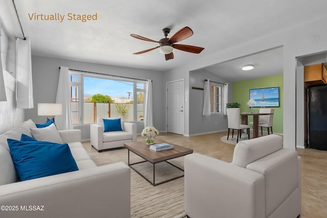 living room with baseboards and ceiling fan