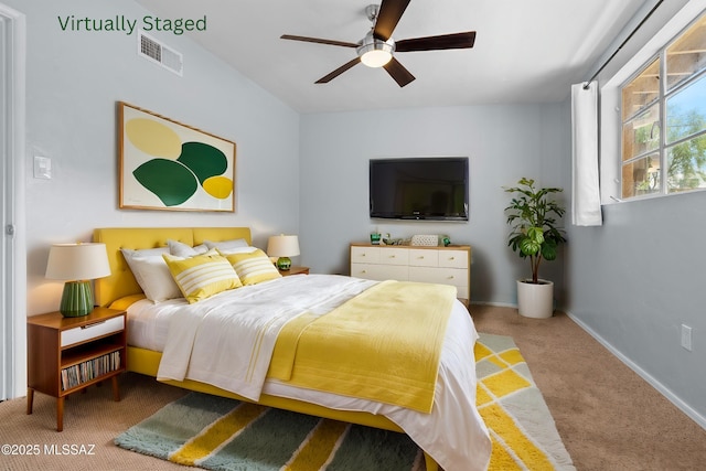 carpeted bedroom with visible vents, baseboards, and a ceiling fan