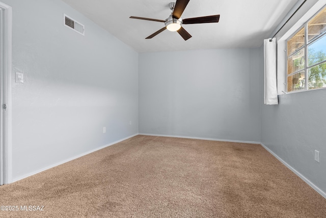 carpeted empty room featuring visible vents, baseboards, and a ceiling fan