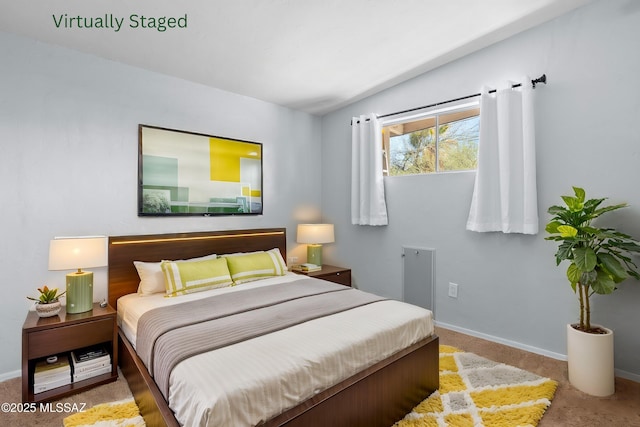carpeted bedroom with baseboards and vaulted ceiling