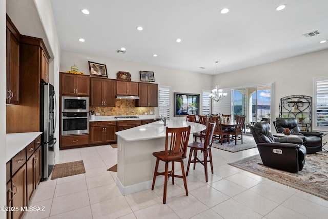 61663 E Talc St, Oracle, AZ 85623 - kitchen featuring a kitchen breakfast bar, a sink, range hood, light countertops, and appliances with stainless steel finishes