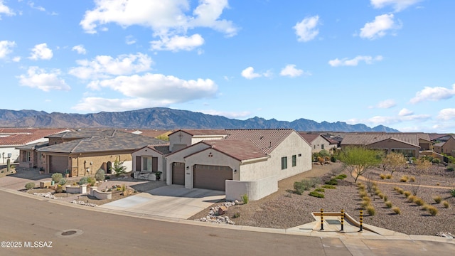 61663 E Talc St, Oracle, AZ 85623 - mediterranean / spanish home featuring an attached garage, a mountain view, stucco siding, and driveway