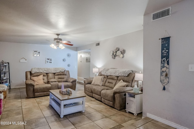 living room featuring light tile patterned floors, baseboards, ceiling fan, and visible vents