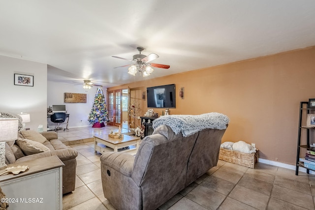 living room with baseboards, light tile patterned flooring, and a ceiling fan