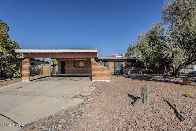 view of front of home featuring a carport, brick siding, and concrete driveway