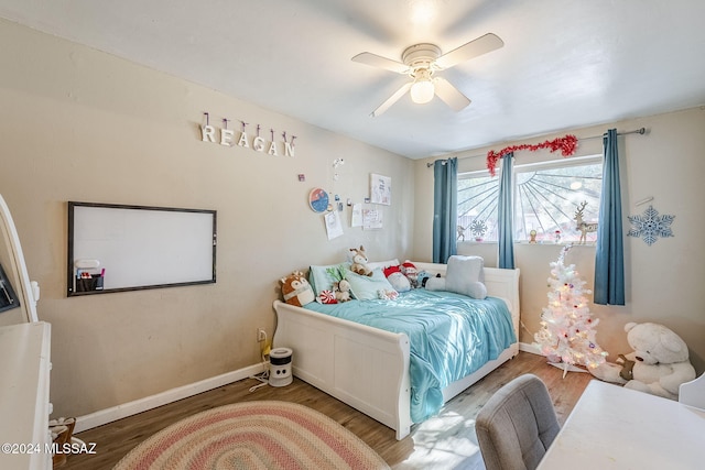 bedroom with baseboards, wood finished floors, and a ceiling fan