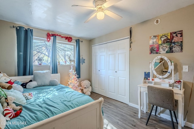 bedroom with a closet, ceiling fan, baseboards, and light wood-style floors