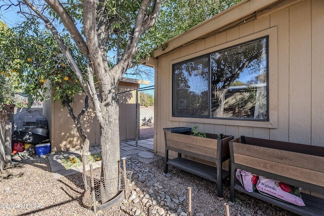 view of side of home with an outdoor structure, a shed, and fence