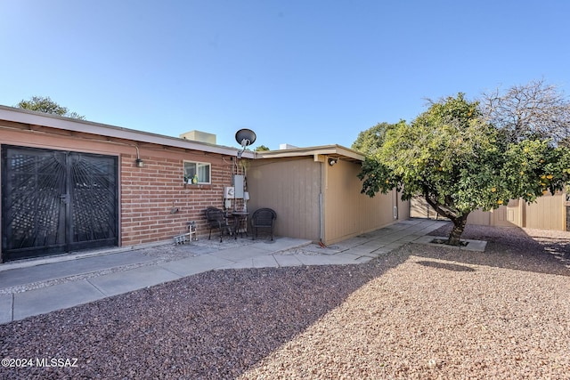 back of house featuring a patio area and brick siding