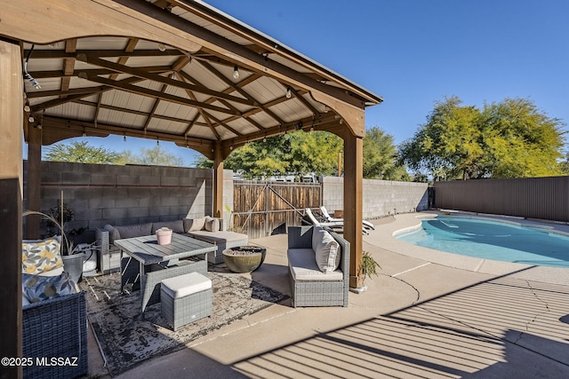 view of pool with a patio, a fenced in pool, a fenced backyard, and an outdoor living space with a fire pit