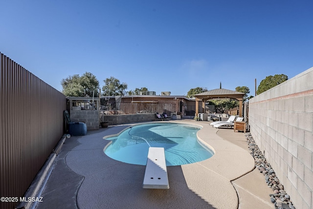 view of pool featuring a fenced in pool, a fenced backyard, a gazebo, a diving board, and a patio area
