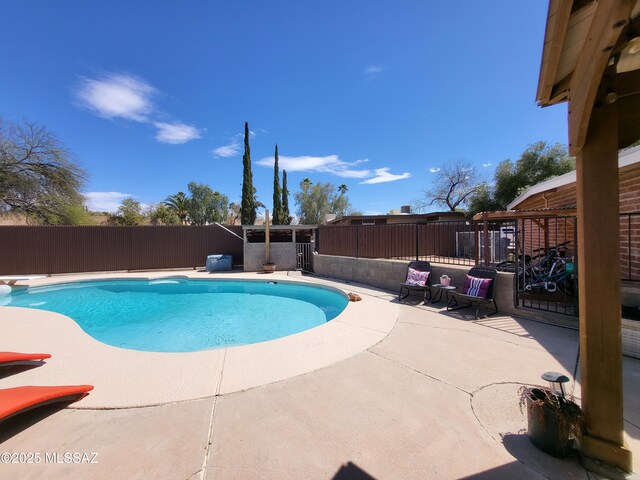view of swimming pool with a diving board, a fenced backyard, a fenced in pool, and a patio