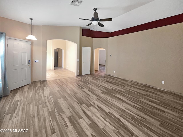 interior space with arched walkways, ceiling fan, visible vents, and wood finished floors
