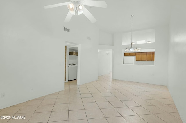 unfurnished room with visible vents, high vaulted ceiling, washer / dryer, and light tile patterned floors