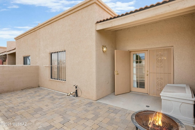 view of patio featuring a fire pit and fence