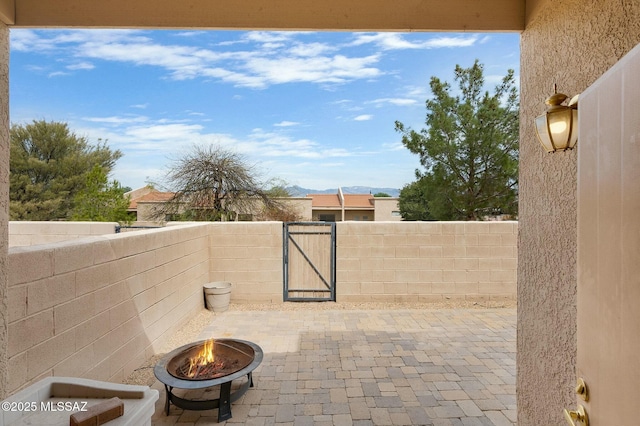 view of patio / terrace featuring an outdoor fire pit, a gate, and fence