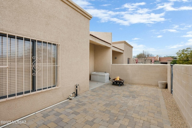 view of patio / terrace with a fire pit and fence