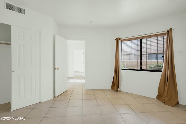unfurnished bedroom with light tile patterned flooring and visible vents