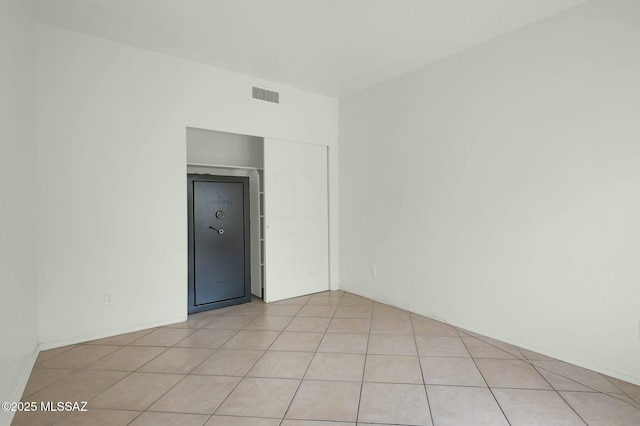 spare room featuring light tile patterned flooring and visible vents