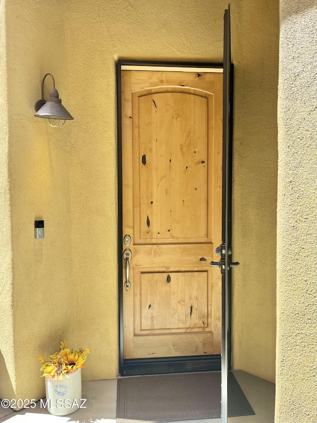 view of exterior entry featuring stucco siding