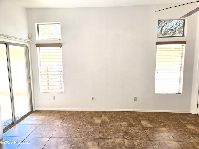 spare room featuring baseboards and a healthy amount of sunlight