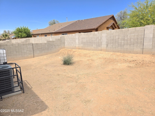 view of yard with a fenced backyard and central AC unit