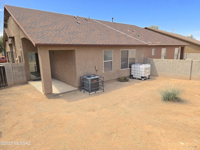 back of property featuring roof with shingles, cooling unit, fence, a patio, and stucco siding