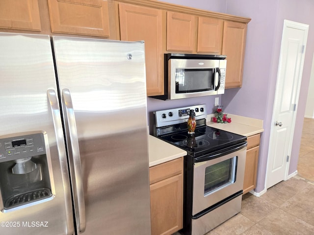 kitchen featuring light tile patterned floors, light brown cabinetry, stainless steel appliances, and light countertops