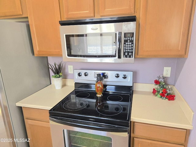 kitchen with light brown cabinets, light countertops, and appliances with stainless steel finishes