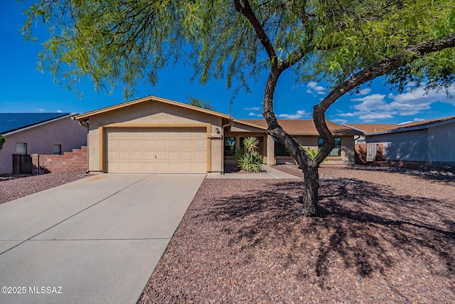 single story home featuring stucco siding, a garage, concrete driveway, and fence