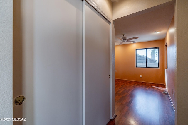 corridor with baseboards and dark wood-style flooring