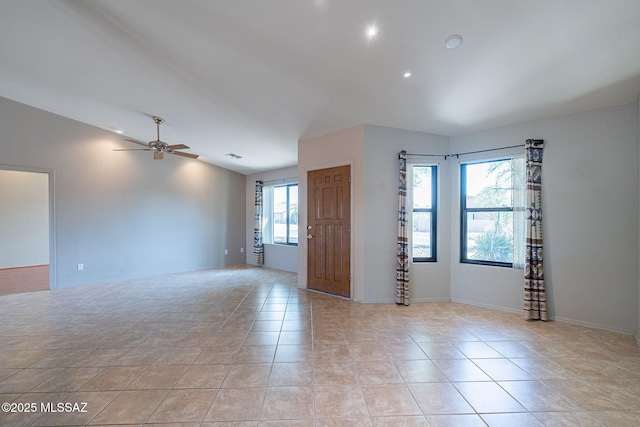 spare room with light tile patterned flooring, baseboards, lofted ceiling, and ceiling fan