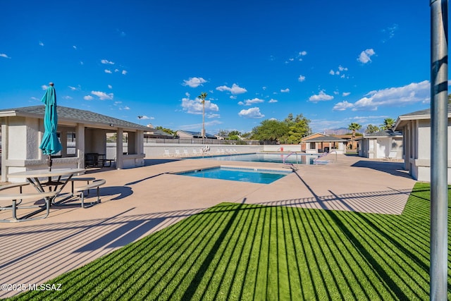 pool with fence, a yard, and a patio area