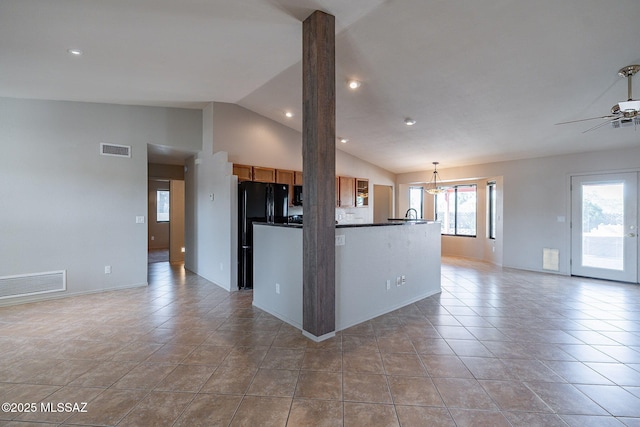 kitchen with open floor plan, visible vents, dark countertops, and freestanding refrigerator
