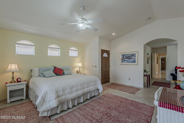 64235 E Greenbelt Ln, Saddlebrooke, AZ 85739 - bedroom featuring light tile patterned floors, arched walkways, a ceiling fan, lofted ceiling, and baseboards