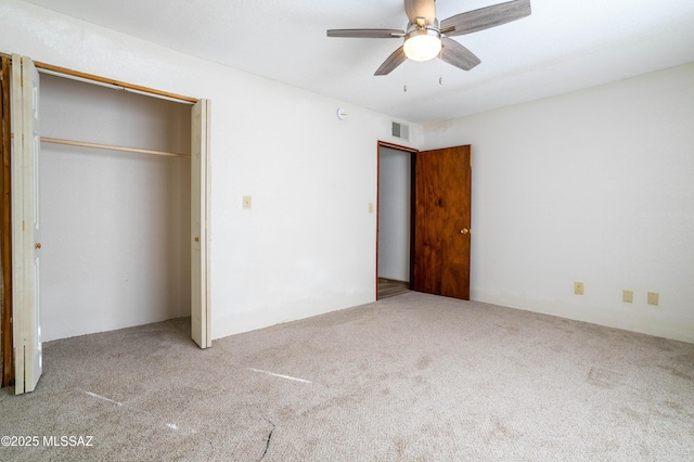 unfurnished bedroom with a closet, carpet floors, visible vents, and a ceiling fan