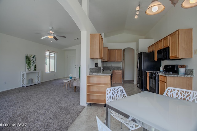 kitchen with ceiling fan, arched walkways, a sink, open floor plan, and black appliances