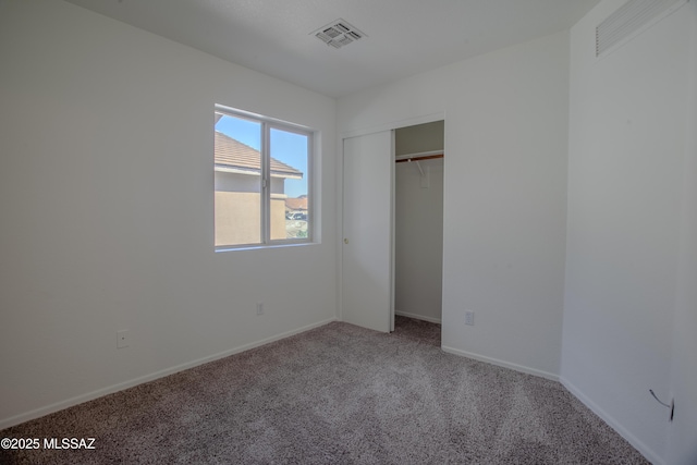 unfurnished bedroom with baseboards, visible vents, a closet, and carpet floors