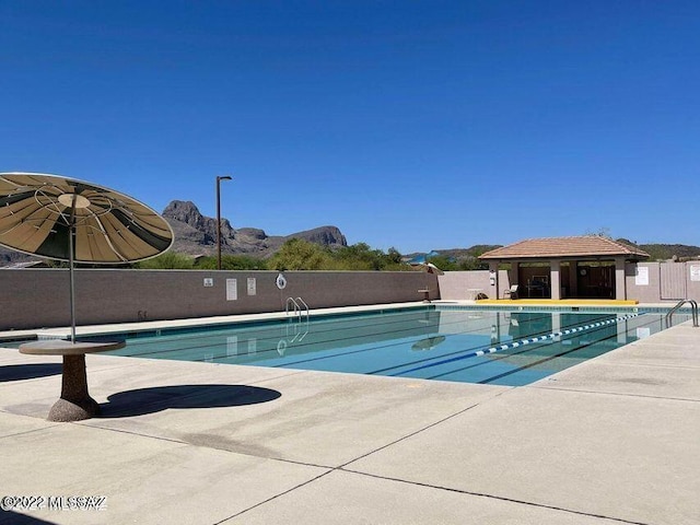 community pool with fence and a patio area