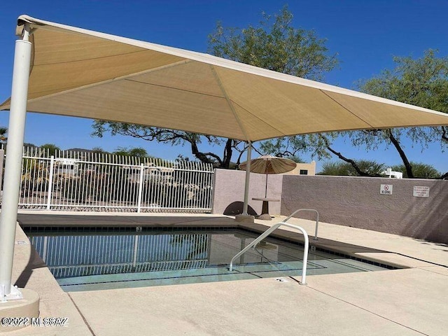 view of pool featuring fence and a patio