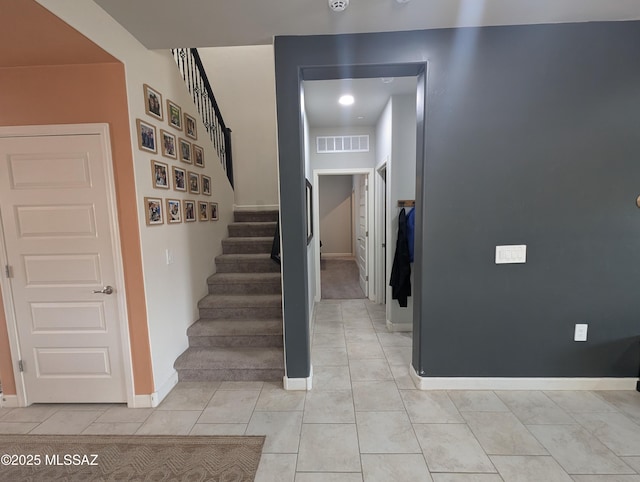 stairs with tile patterned flooring, visible vents, and baseboards