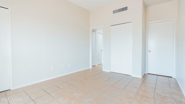 unfurnished bedroom with baseboards, visible vents, and light tile patterned floors