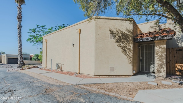 view of property exterior featuring stucco siding and fence