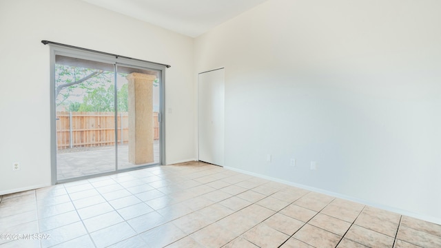 empty room with light tile patterned flooring and baseboards